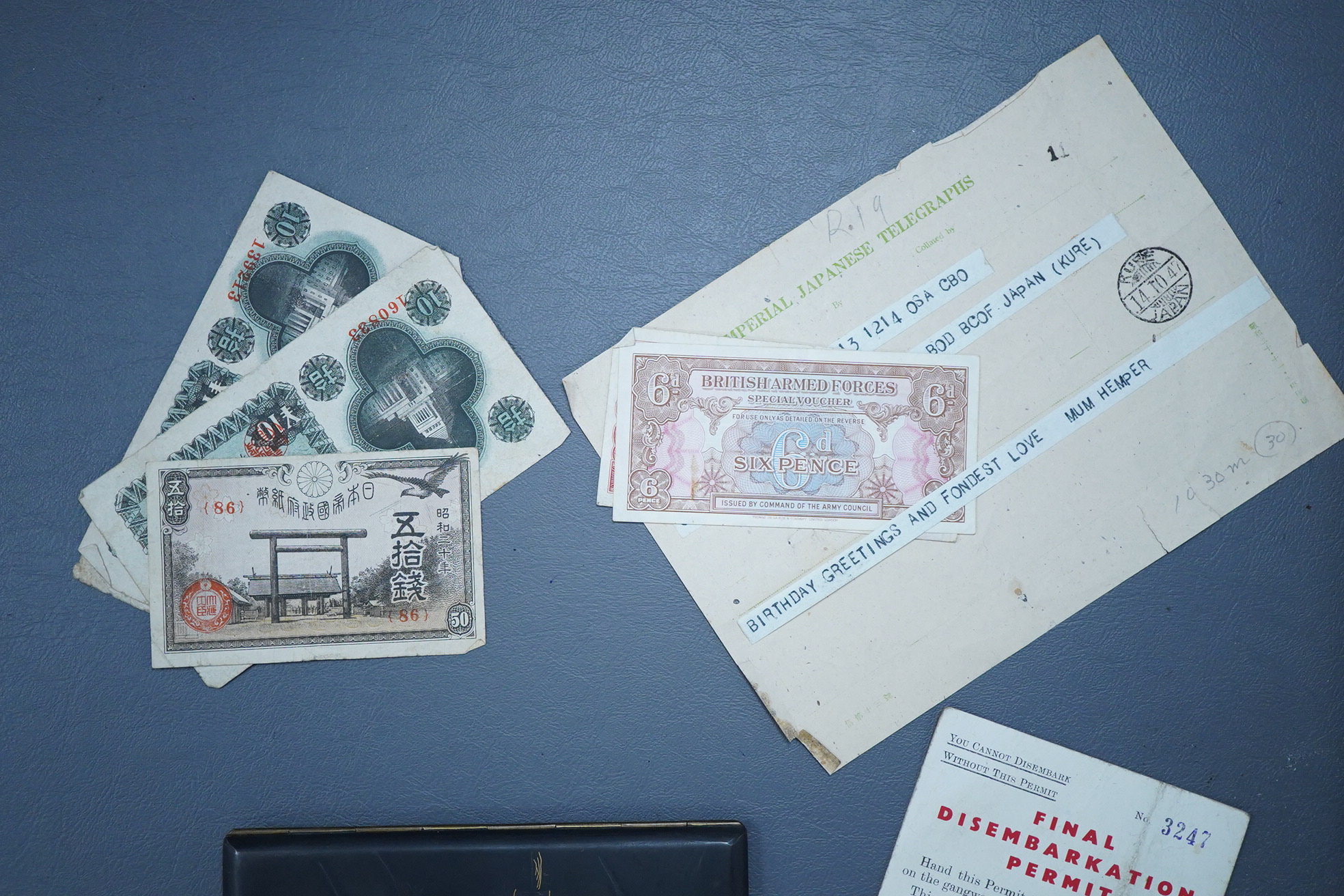 A Japanese photograph album, late 1940's to include banknotes and a telegram, together with a cigarette case